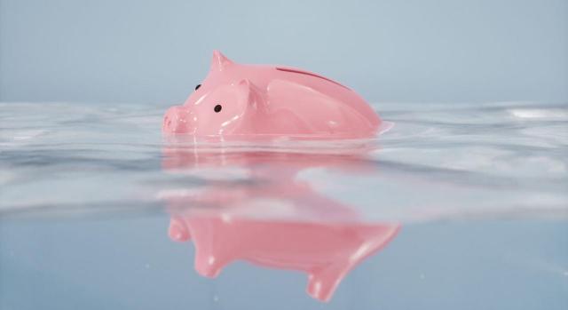 En los créditos concursales el SMI regulador debe ser el vigente en el momento del reconocimiento del crédito por la administración concursal. Imagen de una hucha cerdito rosa hundiendose en el agua