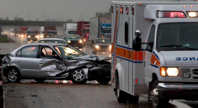 Accidente in itinere como consecuencia del servicio. Imagen de accidente de coche en autopista atascada, presencia de ambulancia