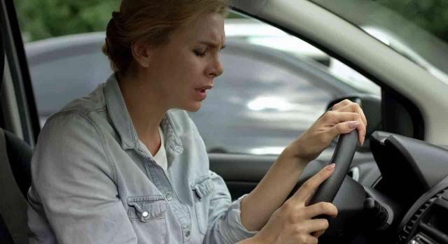 Accidente de tráfico. Conductora al volante sintiendo mareos