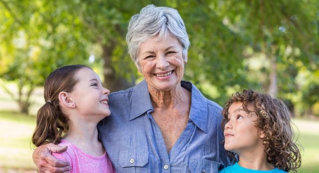 La asignación por acogimiento de nietos menores de edad no computa a efectos de devengar una pensión de jubilación no contributiva. Existe identidad de razón con la exclusión de las asignaciones por hijo a cargo. Imagen de una familiar sonriendo