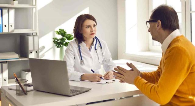 Un paciente hablando con su doctora en la consulta