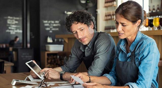 La referencia a "convenio, pacto o contrato" del art. 147.2 c) TRLGSS, como supuestos excluidos de la exención, incluye a los convenios colectivos. Imagen de un hombre y una mujer sentados en una cafetería discutiendo finanzas