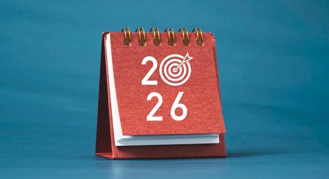 Consulte el calendario de fiestas laborales 2026. Imagen de un calendario en tonos rojos con el año 2026 en la portada sobre fondo azul