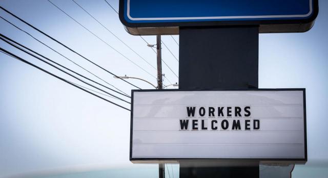 Cuadro comparativo de cambios en el Reglamento de extranjería. Imagen de letrero con la leyenda: Trabajadores Bienvenidos 