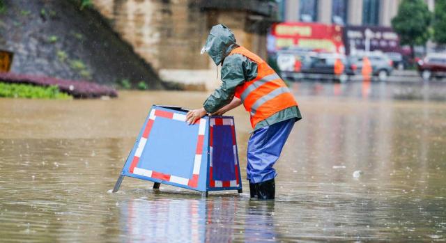 Medidas sociolaborales: zonas afectadas por emergencias de protección civil. Imagen de trabajadores municipales poniendo señalización en calle inundada