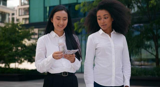 No constituye doble escala salarial la percepción de unos complementos en función de la fecha de ingreso cuando se establecen para compensar la pérdida de otros. Imagen de dos chicas estudiantes contando dinero