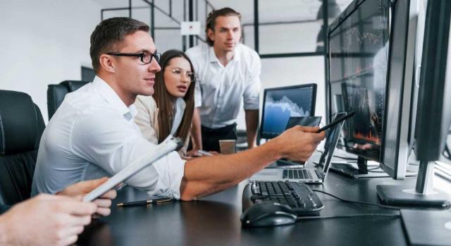 Sucesión de empresa. Fusión por absorción. Derecho de los trabajadores subrogados a que se les aplique cualquier acuerdo de empresa pactado colectivamente AN. No cabe la equiparación automática de condiciones extraconvencionales en la sucesión de empresas: prevalece el mantenimiento de derechos sobre la mejora forzosa. Imagen de un chico enseñando algo en el ordenador a sus compañeros