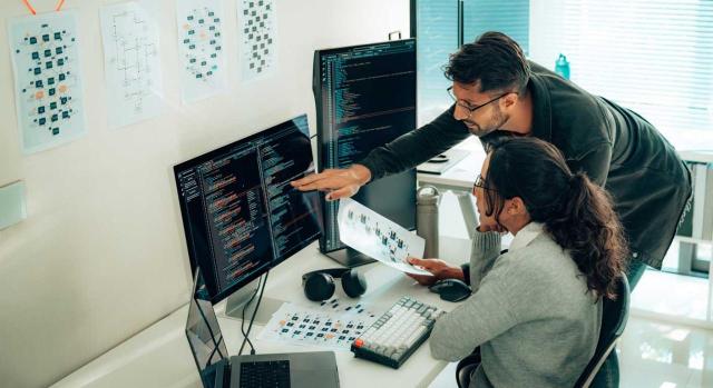 Retribución estratégica: claves para atraer y retener talento que impulsan el éxito empresarial. Imagen de unos chicos trabajando con un ordenador