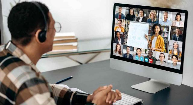 Un chico asiste a una clase online con muchos alumnos