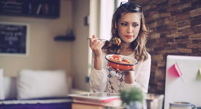 compensación por comida; teletrabajo. Imagen de una mujer almorzando