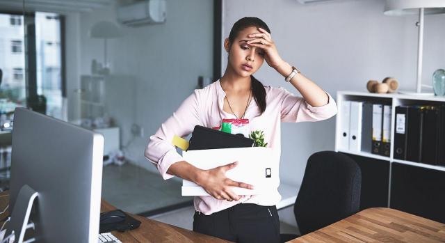 ¿Cómo comunicar el despido a un trabajador? Imagen de una chica con una caja con sus cosas de trabajo y una cara muy preocupada al ser despedida