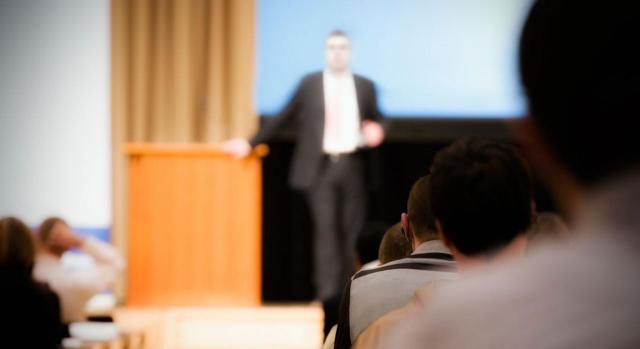 Contratos predoctorales. Imagen difuminada de un hombre dando una conferencia