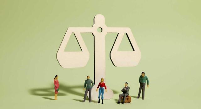 Cambio de convenio colectivo: cuándo puede hacerlo la empresa y derechos del trabajador. Imagen de una balanza y personitas por delante de ella