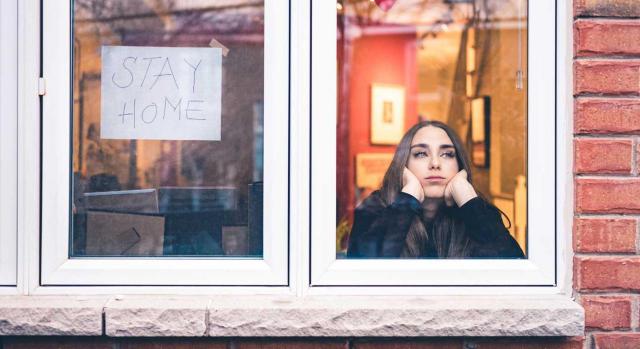 El derecho fundamental a las vacaciones no se ve afectado. Imagen de chica mirando a través de la ventana, cuarentena