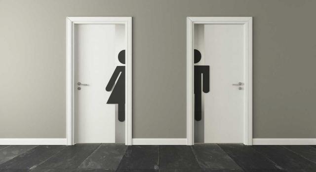 Tiempo de trabajo. Decisión de la empresa de no considerar como tiempo de trabajo efectivo, ante los abusos cometidos por algunos trabajadores. Imagen de puertas de baño blancas para hombres y mujeres