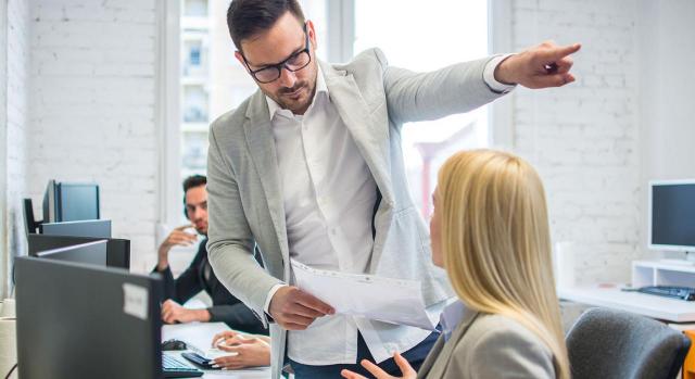 Despido de trabajadora con jornada reducida por guarda legal que no cumple el nuevo horario impuesto unilateralmente por la empresa. Imagen de un jefe apuntando a la puerta de salida a una empleada