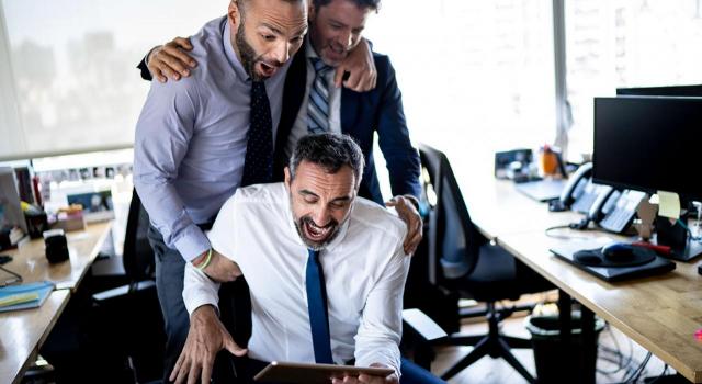 Despido disciplinario. Imagen de unos compañeros de trabajo viendo un deporte en una tablet en horario de trabajo