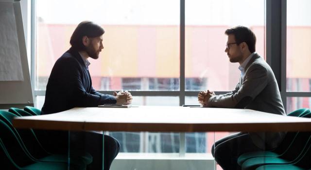 El despido es nulo. Imagen de dos empresarios sentados frente a frente en una mesa negociando