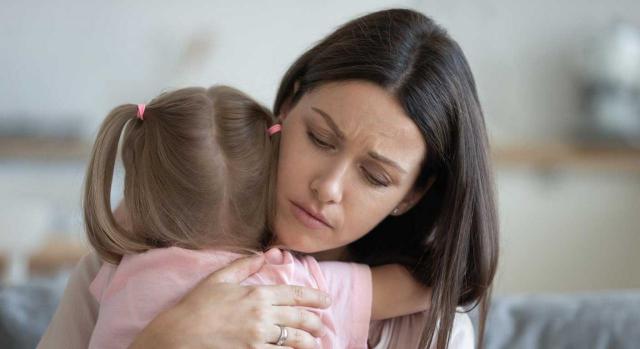 Despido objetivo. Madre abrazando a su hija con gesto de preocupación