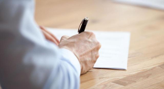 El Tribunal Supremo declara nulo el despido de un trabajador un día después de hacer una reclamación interna por falta de pago del exceso de jornada. Imagen de un hombre firmando un papel