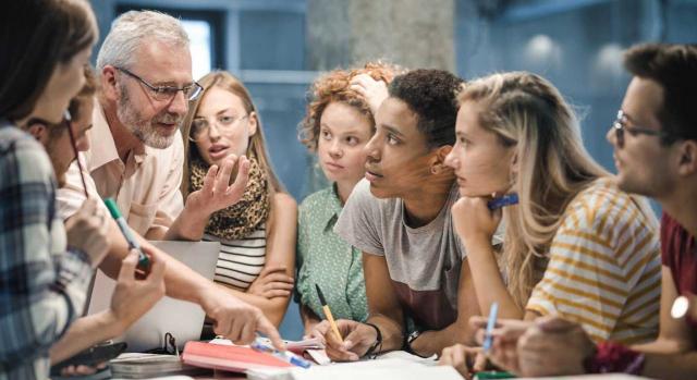 Doble escala salarial. Imagen de profesor enseñando a un grupo de estudiantes en el campus