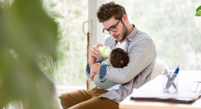 ¿Cuál es la duración del permiso de lactancia acumulada? Imagen de padre joven dando de comer al bebé