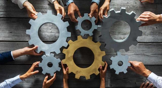 Objetivo empleo Objetivo empleo. Varios engranajes sostenidos por ejecutivos que tratan de encajarlos