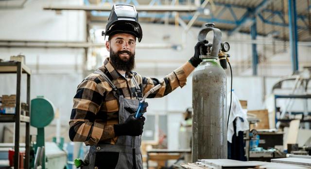 Trabajador, menor de 30 años, que presta servicios para su padre, afiliado al RETA, en virtud de un contrato de trabajo y que no convive con el mismo. Imagen de un trabajador con un soldador en la mano