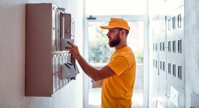 El personal laboral de Correos con contrato de duración determinada tiene derecho a recibir las mismas prendas del uniforme que las que la empresa viene suministrando al personal laboral indefinido y fijo. Imagen de un chico de correos entregando facturas en los buzones
