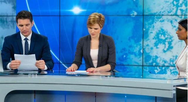 Interinidad por sustitución. Dos presentadores de noticias de TV, comprobando sus notas antes de empezar
