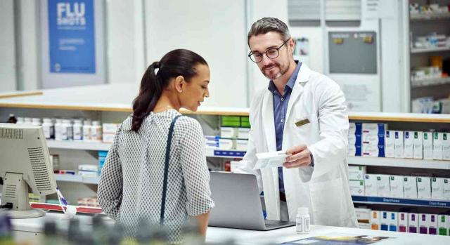 Un farmacéutico da un medicamento a un cliente