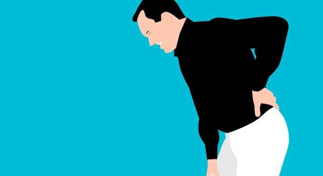 Despido objetivo por ineptitud sobrevenida: límites y carga de la prueba de la obligación de readaptación y recolocación en un puesto de trabajo compatible. Imagen de la figura de un hombre agachado por su dolor de espalda
