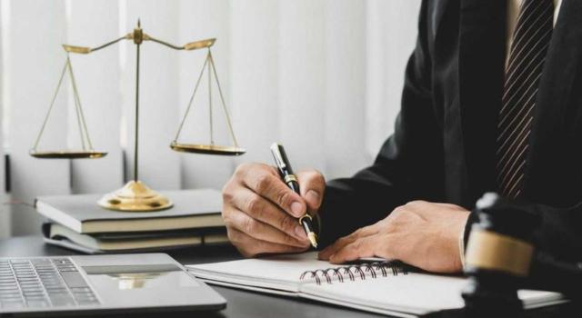 Demanda de revisión. Sentencia dictada por Juzgado de lo Social que declara improcedente el despido disciplinario de un trabajador por falta de acreditación de los hechos contenidos en la carta de despido Demanda de revisión: una condena penal basada en un acuerdo (conformidad) no se considera automáticamente un «documento recobrado» que permita reabrir un caso de despido. Imagen de un hombre en un escritorio con la balanza de juez a su lado