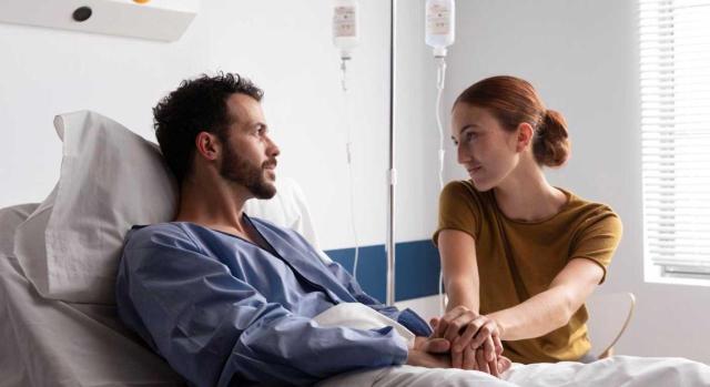Licencias retribuidas. Permiso por accidente, enfermedad grave sin hospitalización u hospitalización, o intervención quirúrgica sin hospitalización La Audiencia Nacional rechaza que el permiso por hospitalización deba disfrutarse de forma continuada dentro de un determinado arco temporal. Imagen de una mujer sentada junto a su marido ingresado en el hospital