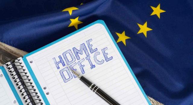 Un cuaderno y una pluma sobre una bandera de la UE