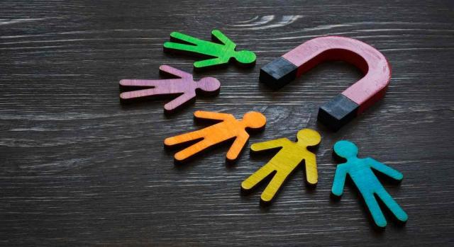 Un imán atrae a cinco figuras con forma de personas cada una de un color diferente