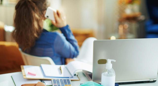 Todo lo que necesitas saber sobre el ingreso mínimo vital. Imagen de mujer hablando por teléfono con máscara médica y desinfectante de manos