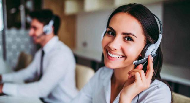 Retribución contrato. Mujer sonriendo y su compañero en el puesto de trabajo