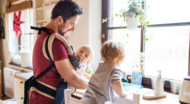 Padre y dos niños pequeños que lava los platos. Jornada de adaptación de reducción de turnos parental