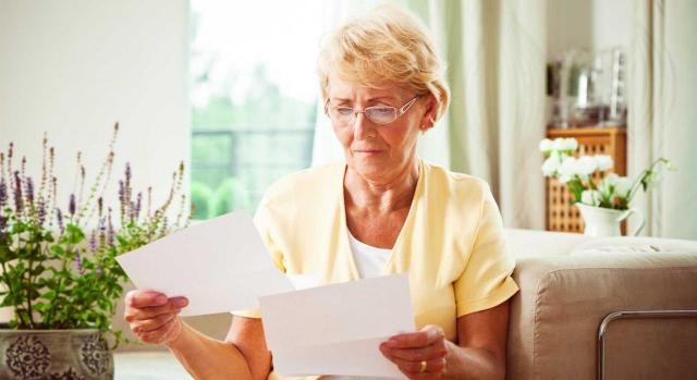Cómputo del servicio social para jubilación anticipada. Mujer mayor mirando unos papeles