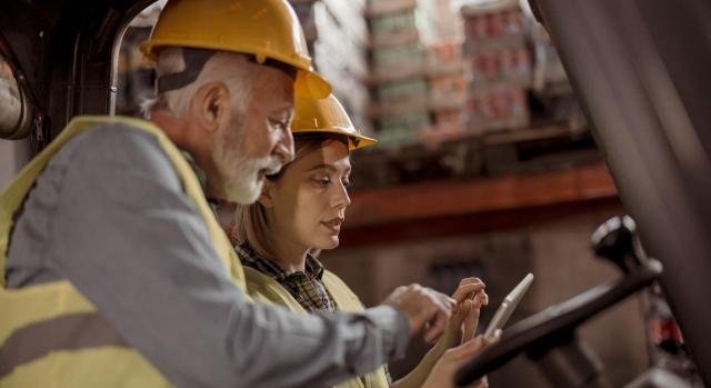 jubilacion-parcial-contrato-relevo-base-cotizacion-jornada-reducida. Imagen de trabajadores de almacén consultando una tablet