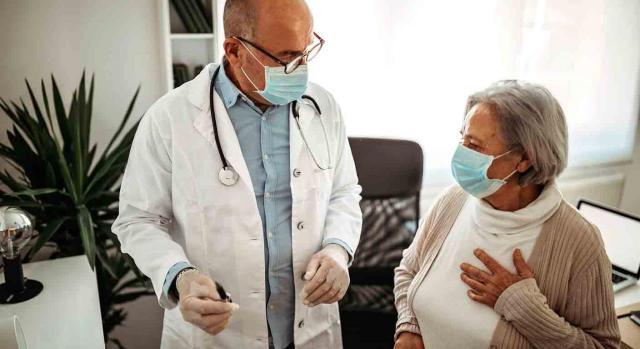 Personal estatutario de las profesiones sanitarias. Médico hablando con paciente en consulta