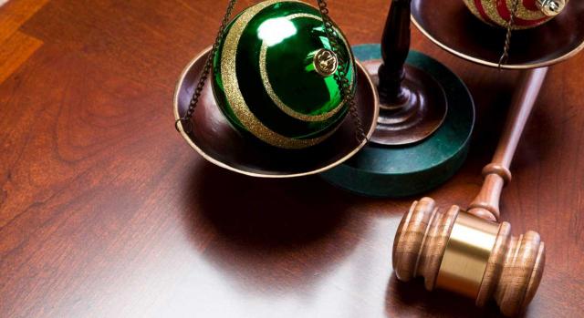 Jurisprudencia. Imagen de mazo y balanza judicial con bolas de navidad