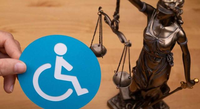 Discapacidad. Valoración de las dolencias en el estado en que se encuentran en el momento del juicio oral cuando ha transcurrido largo tiempo entre la valoración administrativa y la judicial Valoración del grado de discapacidad. ¿Qué ocurre cuando transcurre un lapso de tiempo importante entre la resolución administrativa y la celebración del acto del juicio? Imagen de la figura de la justicia junto a una pegatina de discapacitado en silla de ruedas
