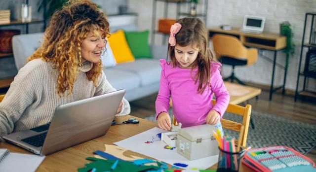 Complemento por brecha de género en la pensión: requisitos, cuantía y cómo solicitarlo Complemento de la pensión por brecha de género: qué es, quién puede solicitarlo y cuánto aumenta la pensión. Imagen de una mujer trabajando en el salón de su casa mientras ayuda a hacer los deberes a su hija pequeña