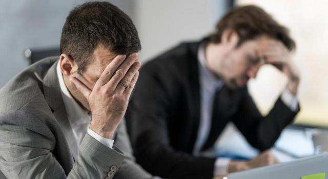 RR.HH.: malas prácticas más comunes, sus consecuencias y cómo evitarlas. Dos empresarios con exceso de trabajo en la oficina