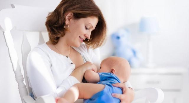 Conciliación cambio sede. Una madre mirando a su bebé en brazos