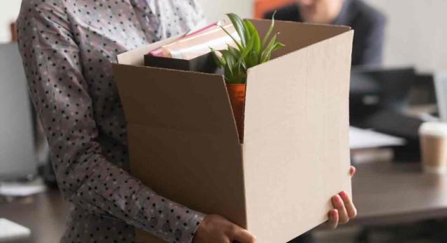 Funcionaria interina; no discriminación; abuso; personal laboral fijo. Mujer llevando una caja con sus cosas del trabajo