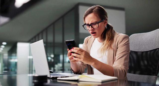 Condenada una empresa a pagar 10.000 euros a una trabajadora por incluir la expresión “zumbada” en la casilla correspondiente a «beneficiario» en el momento de abonar el salario mediante transferencia bancaria. Imagen mirando el movil muy enfadada