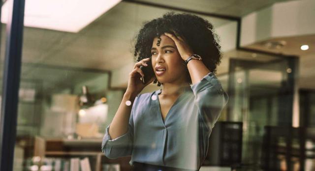 Excedencia voluntaria; despido tácito; sucesión de empresa. Mujer hablando por teléfono con cara de preocupación